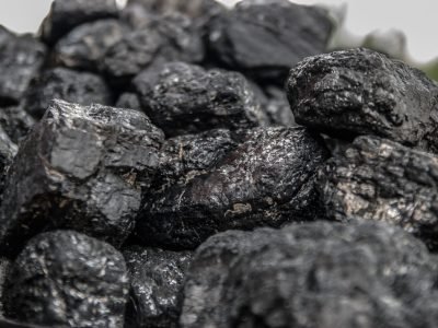Home Detailed image of dark, textured coal pieces in a close-up view, highlighting their rugged surface.